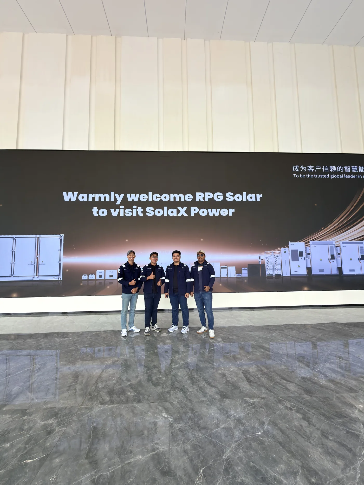 The RPG Solar team visiting SolaX Power's factory in China, welcomed on the company's digital signage